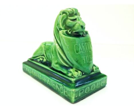 A Poole Pottery Carter Stabler Adams green glazed stoneware advertising paperweight modelled as a 'lion restant' with shield 