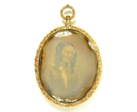 A 19TH CENTURY CHASED GOLD PORTRAIT MINIATURE FRAME CONTAINING A SLIGHTLY LATER DAGUERREOTYPE PHOTOGRAPH OF A LADY