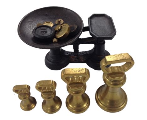 A graduated set of four brass weight together with a set of vintage scales with further weights.