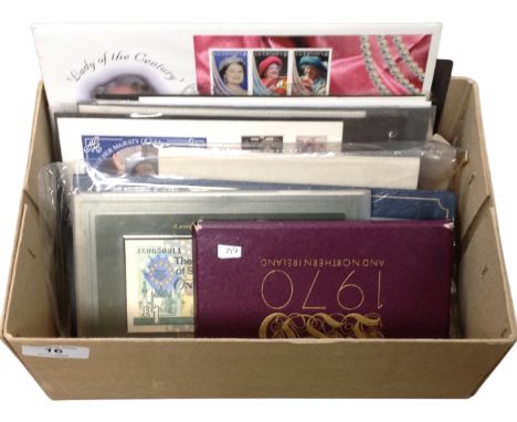 A box containing First Day coin covers, Royal Bank of Scotland one pound note, Commemorative Apollo space mission stamp coin 