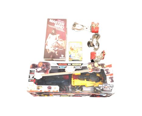 A remote controlled model car set together with a pair of vintage roller skates and Deluxe Mastermind game.