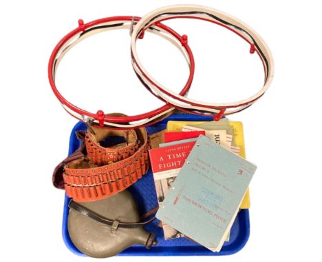 A collection of infantry training manuals and other military related books, a leather ammunition belt, a flask, two drum rims