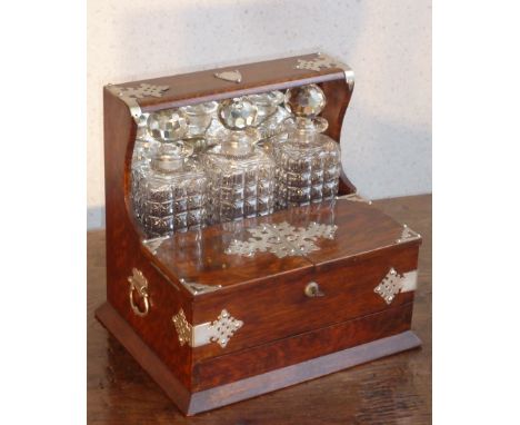 A late 19th Century oak and silver plated mounted three bottle 'games' Tantalus, the two part hinged front opening to reveal 