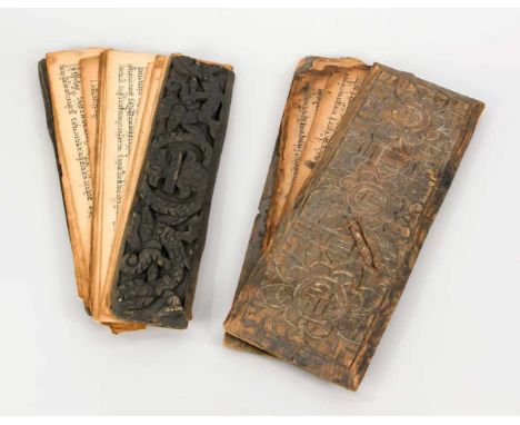2 Palmblattmanuskripte, Südostasien, 19. Jh., beschnitzte Holzeinbände. Dazwischen lose Manuskriptseiten mit Schrift. Stärker
