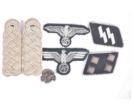 A SMALL COLLECTION OF GERMAN UNIFORM RELATED ITEMS, to include breast eagles, shoulder boards, collar patches, and a cap badg