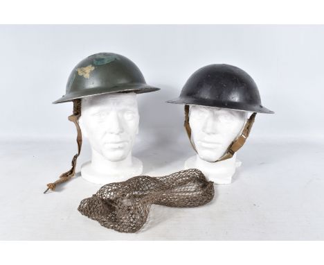 TWO WWII ERA STEEL HELMETS, the first is green  in colour and complete with chin strap and liner, on the sides later paint wo