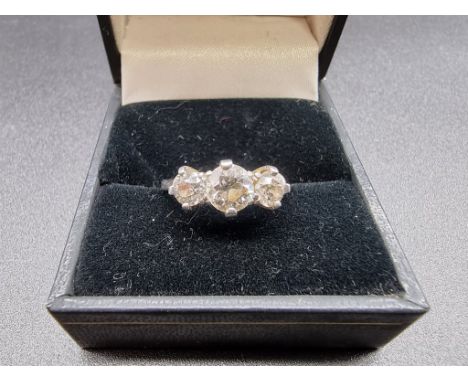 A diamond three stone ring, the central stone approximately 0.66ct and the other two approximately 0.25ct, stamped Plat, size