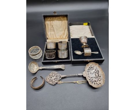 A cased silver three piece Christening set (different makers); together with a cased set of four silver napkin rings, (one no