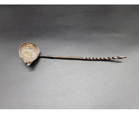A toddy ladle having twisted baleen handle, inset 1758 silver shilling, 34cm long. 