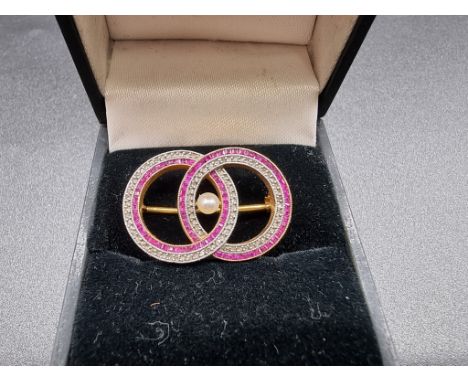 A vintage French ruby, diamond and pearl set concentric circle brooch, stamped 750 and control marks, 26mm. 