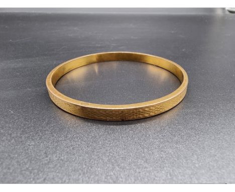 An engine turned 9ct gold bangle, by N C &amp; S, Chester 1925, 82mm diameter, 10.9g. 