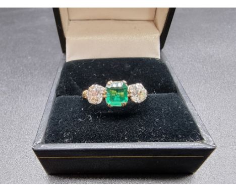 A yellow metal emerald and diamond three stone ring, stamped 18ct, size O. 