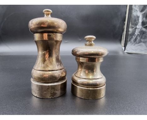 A silver pepper grinder, by W E V, London 1984, 10cm high; together with another smaller example. (2) 