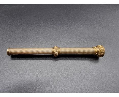 A Victorian engine turned yellow metal pencil holder, having monogrammed cornelian top, 89mm. 