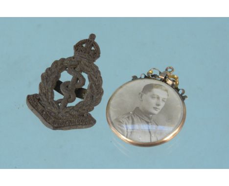 A gold 'open' pendant with photographs plus a Royal Army Medical Corps cap badge