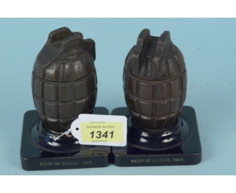 A pair of WWI Mills grenade castings on ceramic bases, script around base 'Memento of the Great War, Actual Hand Grenade Cast