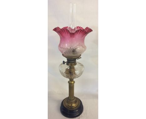 Victorian paraffin lamp on a brass column with a cranberry glass shade