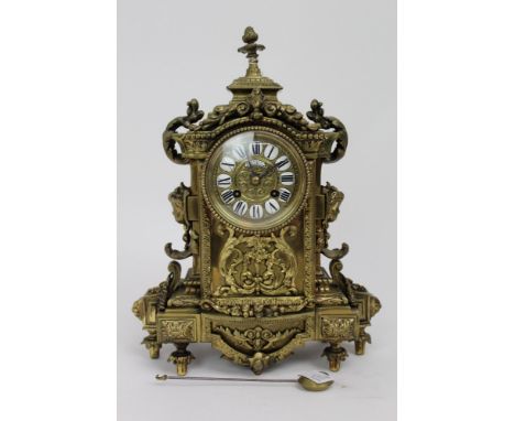 Ornate French brass mantle clock, the enamel dial signed Phillipe Ft, 66 Palais Royal, with pendulum, 38cm height