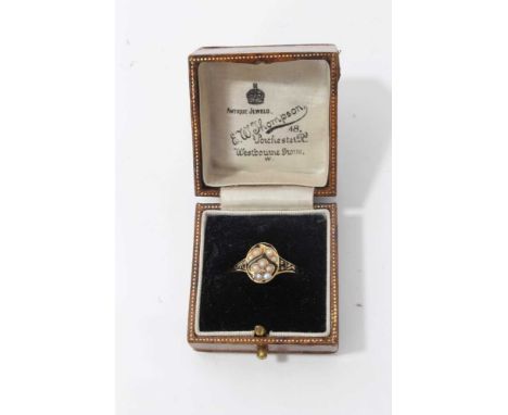 Victorian yellow metal mourning ring set with seed pearls in the form of a flower, with black enamel decoration, band engrave