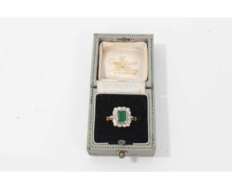 18ct gold emerald and diamond ring with a rectangular stepped cut emerald surrounded by a border of fourteen brilliant cut di