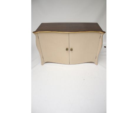 A contemporary serpentine commode style two door sideboard cabinet. With dark stained wood top, guilt edge and brass handles,