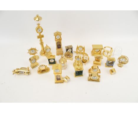 A collection of 22 assorted brass cased miniature novelty clocks/timepieces. Including a long case clock, a boat, a grand pia