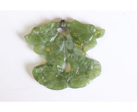 A carved green jade amulet with white metal mount, mount marked with character marks. 