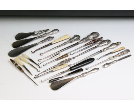 A collection of antique button hooks and shoe horns to include hallmarked sterling silver examples. 