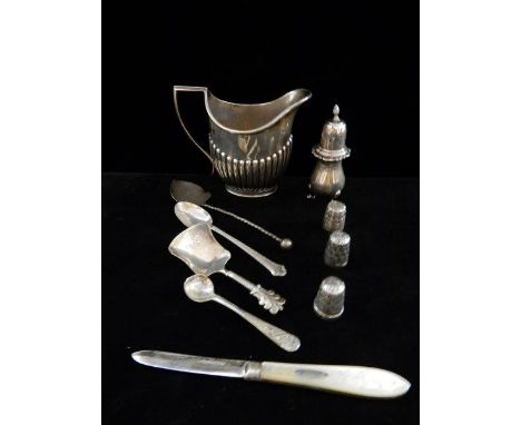 A silver cream jug with half fluted decoration, a silver pepperette, a fruit knife with silver blade and mother of pearl hand