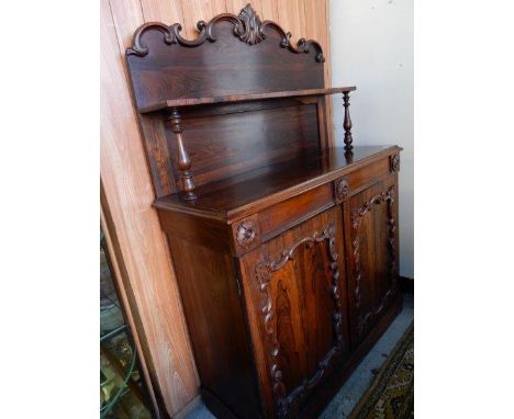 A Victorian rosewood chiffonier, the raised back with leaf scroll decoration, fitted shelf, turned supports, the base fitted 