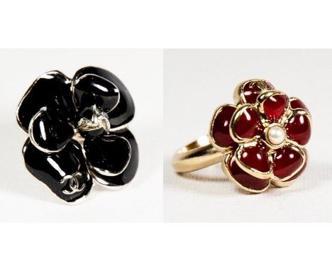 A Chanel dress ring in the form of a black enamel flower, complete with dust bag and one other smaller ditto decorated red en