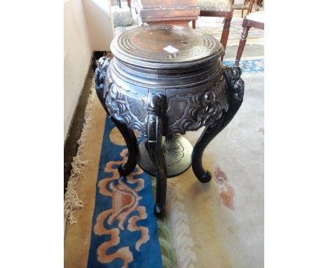 A Chinese ebonised vase stand with circular top, pierced frieze, scroll legs and undertier