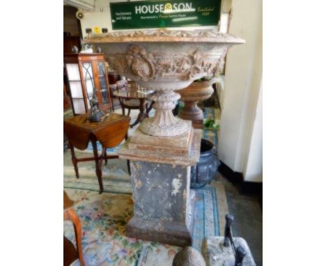A pair of Victorian large cast iron urns with lattice and flower decoration, complete with pedestal bases
