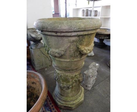 A concrete jardinière decorated fruit and swags and a concrete column decorated flower swags