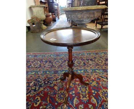 A mahogany occasional table with circular top, on turned column and three downswept legs