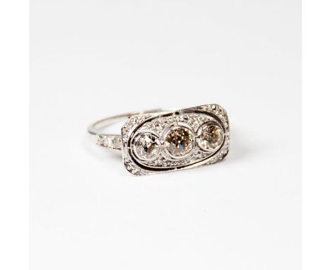 A lady's three stone diamond ring with rub over settings, on an 18ct. white gold shank