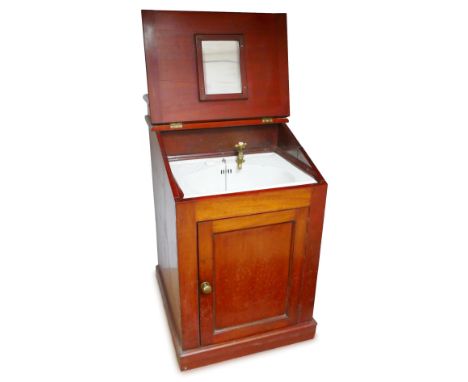 A late 19th/early 20th century ship's cabin vanity wash basin unit, of enclosed form in mahogany cabinet with hinged metal li