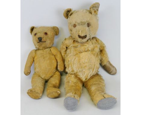 A teddy bear with straw-filled plush body, glass eyes, stitched nose and mouth and jointed limbs 37cm high and another larger