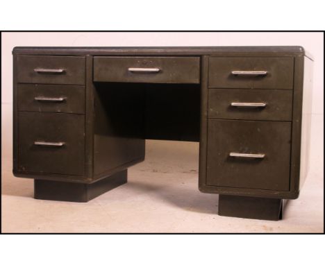 A vintage mid century twin pedestal steel  desk in khaki green having a central long drawer flanked by two banks of three gra