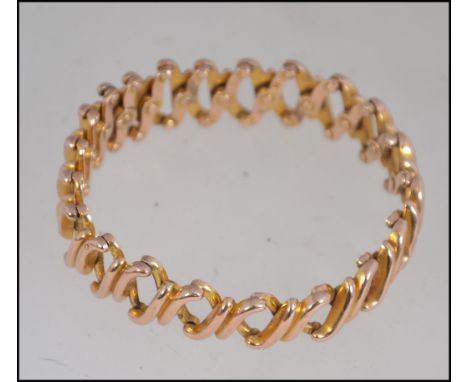 A designer yellow metal (tests for 9ct gold ) articulated expanding bracelet  with expanding links marked Baden, 9, S and pat