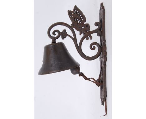 A cast iron exterior hanging garden bell with decorative butterfly bracket. 