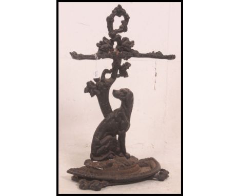 A Victorian cast iron stick stand modelled as a seated dog beneath tangled branches acting as two section umbrella holders ab
