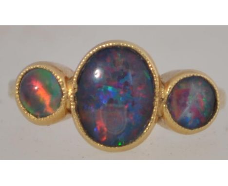 A stunning 18ct gold and 3 stone opal ring of heavy setting, The beautiful stones graduating in size. Total weight 5.8g / Siz