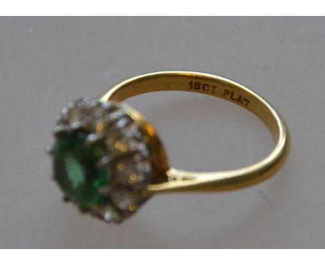 A marked 18ct and platinum green stoned ladies dress ring with diamond surround 4.5g RS N