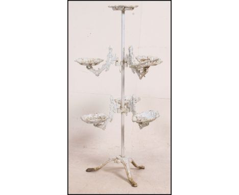 A cast metal Coalbrookdale plant stand having six adjustable bases for plants on the central pole having a stationary one ato
