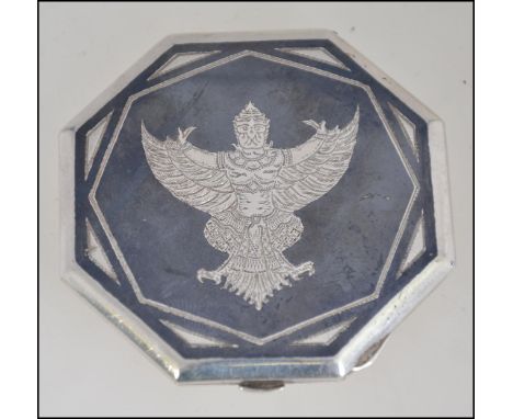 A 20th century silver Siam ladies compact with inset deity decorative top. Weight 59.7g W6cm