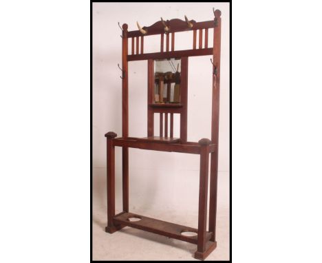 A Victorian mahogany arts and crafts hall stand having central glove box, stick stand recesses with upright back having mirro