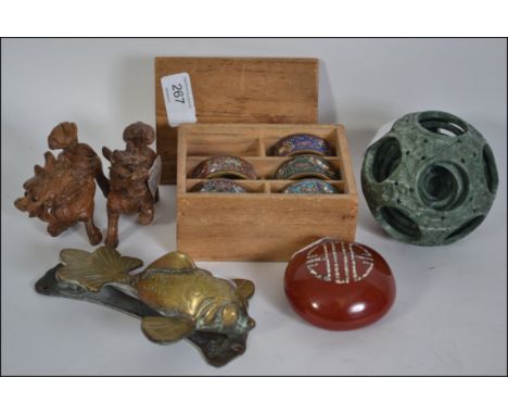 Wooden divided box containing five cloisonne napkin rings, two intricately carved dogs of Foo , a jade like puzzle ball ( 6 )