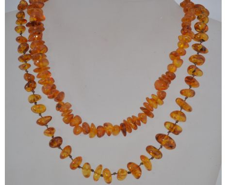 2 good vintage mid century amber string necklaces, the amber of baroque style, one with screw clasp.