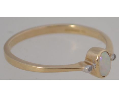 A 9ct gold and opal ladies dress ring of fine form having oval opal flanked by 2 x 1pnt diamonds either side. Total weight 1.